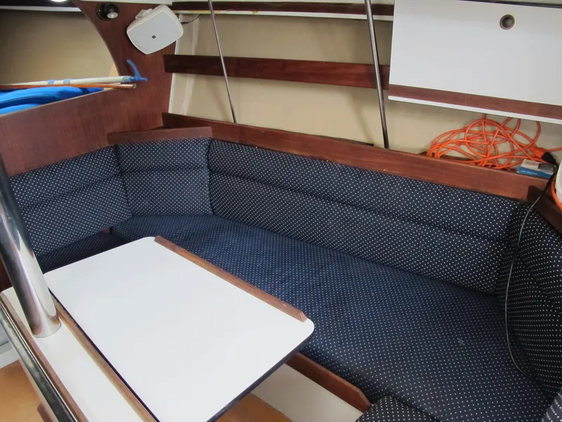 Slide: The Image of 1987 O'Day 322 sailboat interior with blue cushioned seating and white table. - 30