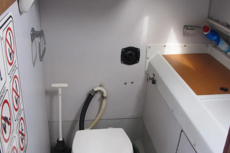 Slide: The Image of 1987 O'Day 322 boat bathroom with toilet, sink, and storage area. - 33