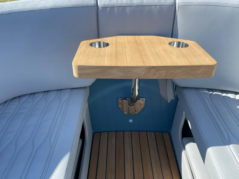 Slide: The Image of 2022 Cranchi 26 Rider boat interior with wooden table and cup holders. - 11