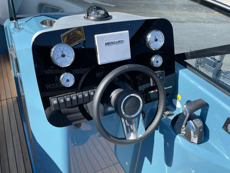 Slide: The Image of 2022 Cranchi 26 Rider boat dashboard with steering wheel and Mercury controls. - 14