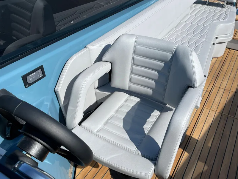 Slide: The Image of 2022 Cranchi 26 Rider boat interior with sleek gray seating and wooden deck. - 17