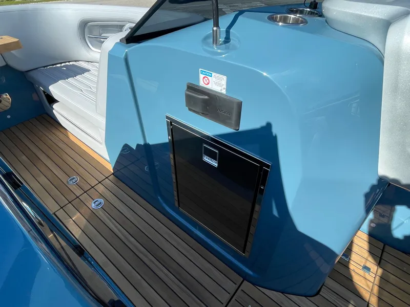 Slide: The Image of 2022 Cranchi 26 Rider boat interior with blue console and wooden flooring. - 19