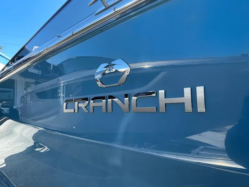 Slide: The Image of 2022 Cranchi 26 Rider boat with sleek blue exterior and chrome logo. - 24