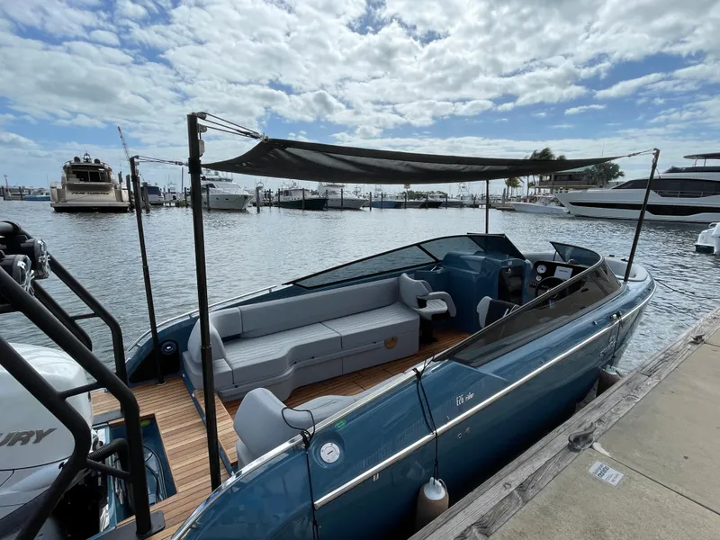 Slide: The Image of 2022 Cranchi 26 Rider boat docked with canopy, featuring sleek design and spacious seating. - 26