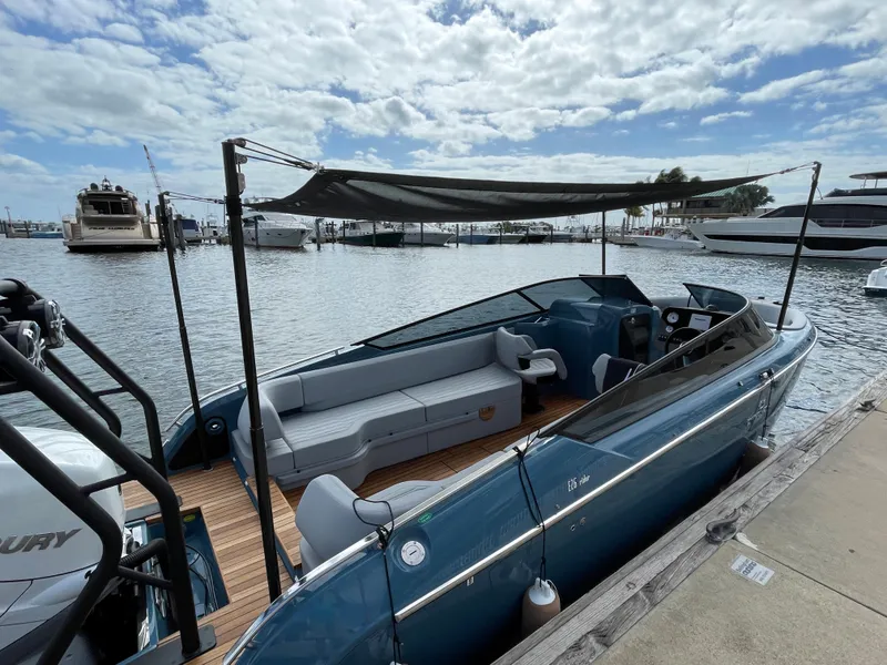 Slide: The Image of 2022 Cranchi 26 Rider boat docked, featuring sleek design and spacious seating under a canopy. - 27