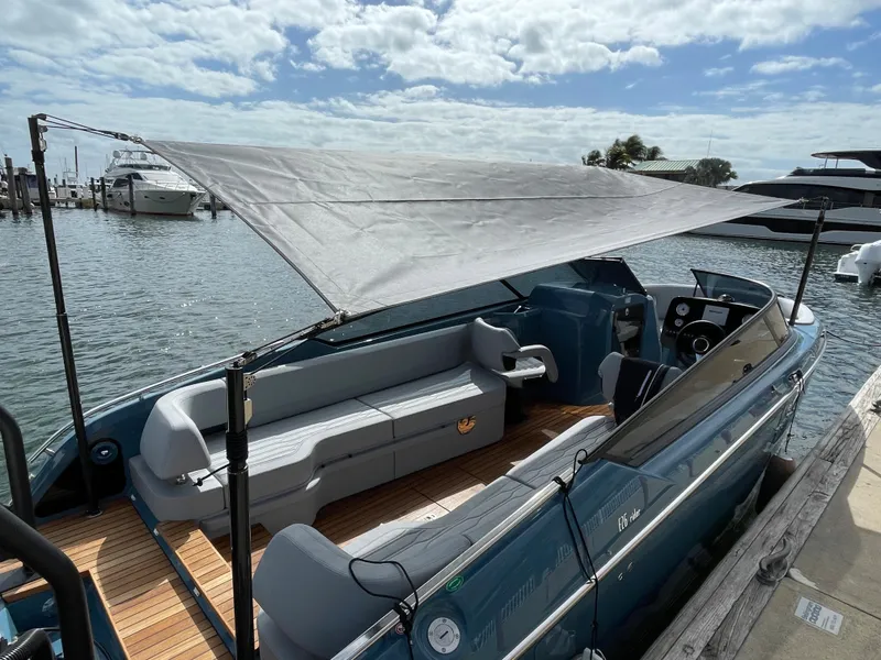 Slide: The Image of 2022 Cranchi 26 Rider boat with canopy, docked by the water under a cloudy sky. - 34