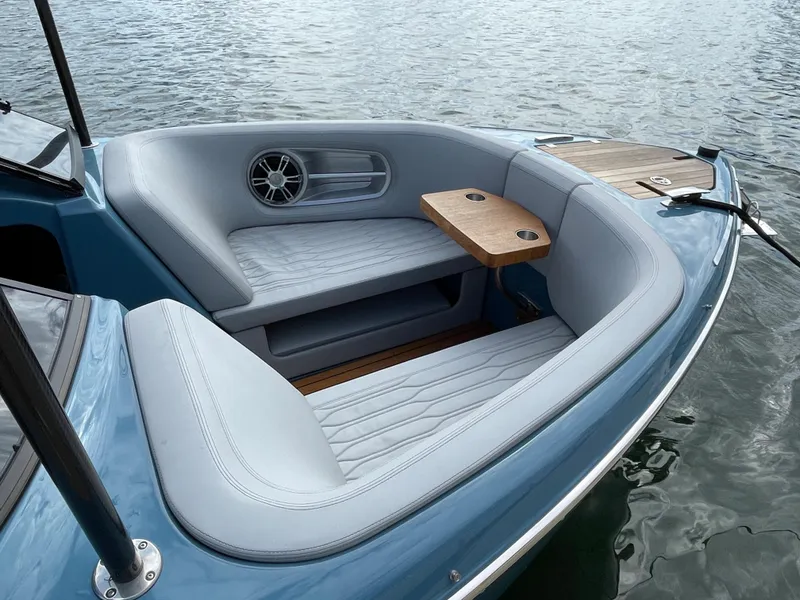 Slide: The Image of 2022 Cranchi 26 Rider boat with elegant seating and wooden table on calm water. - 9
