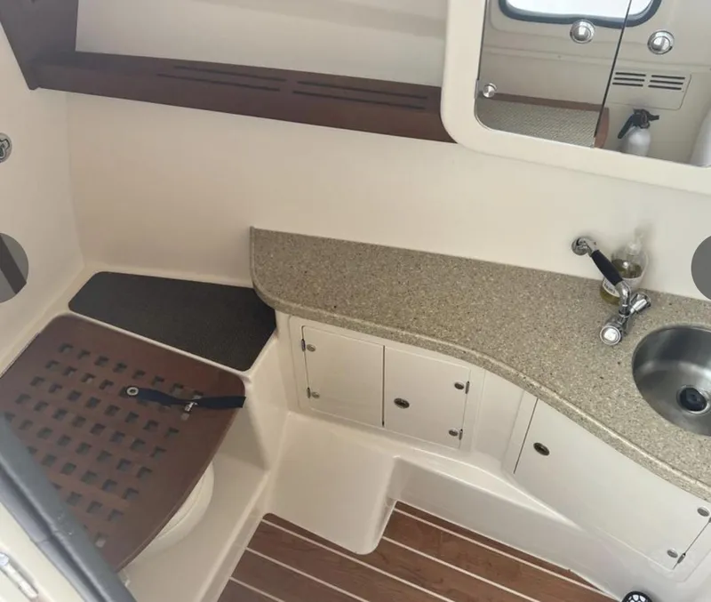Slide: The Image of 2014 Grady-White Freedom 335 boat interior with sink, countertop, and wooden flooring. - 2