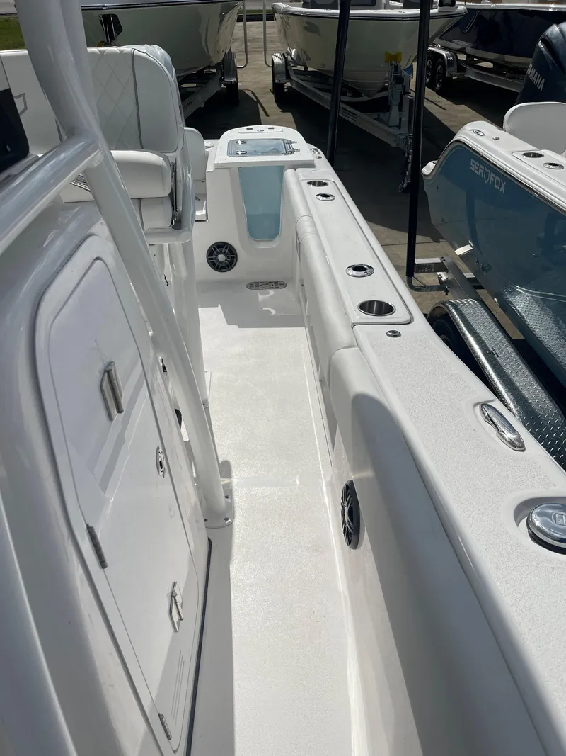 Slide: The Image of 2024 Sea Fox 248 Commander boat interior, featuring white deck and storage compartments. - 15
