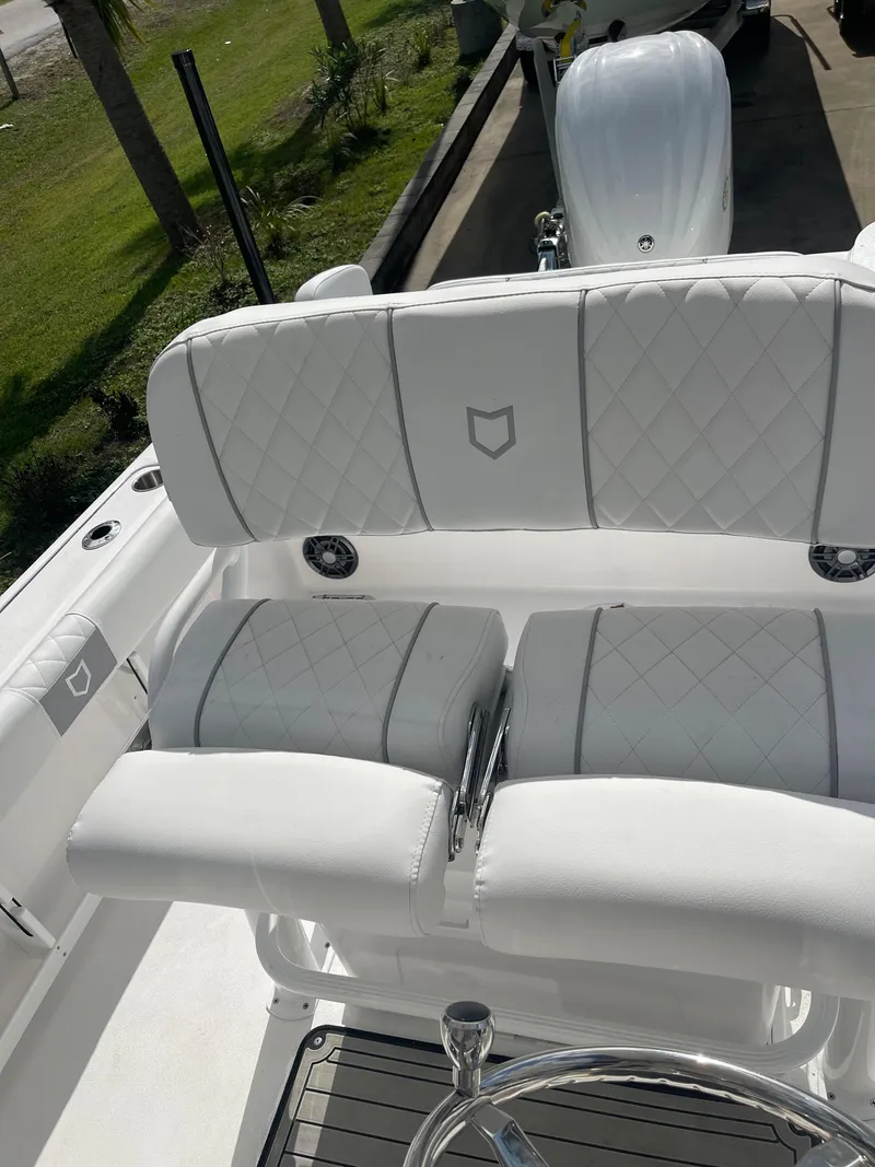 Slide: The Image of 2024 Sea Fox 248 Commander boat with white cushioned seating and steering wheel. - 18