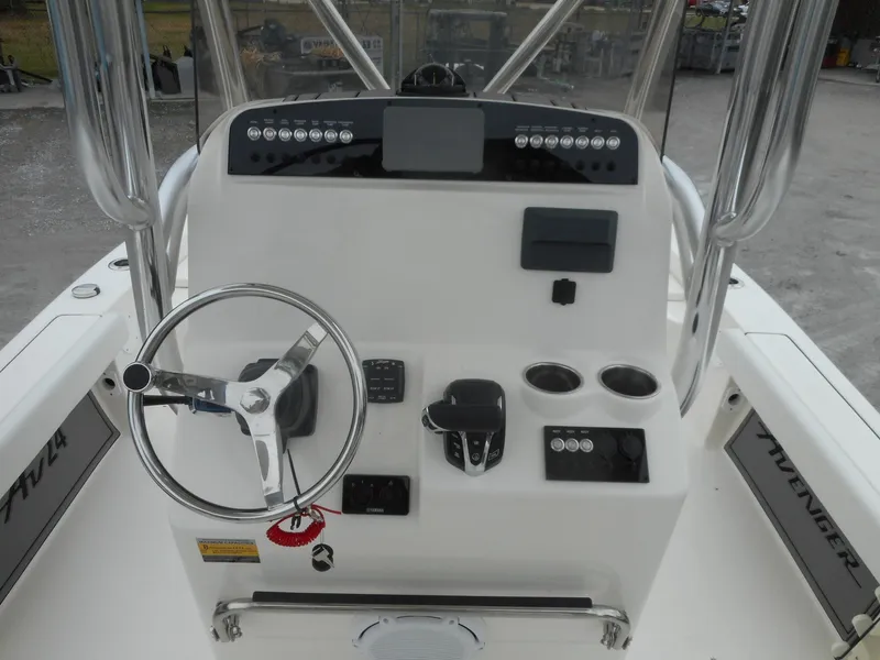 Slide: The Image of 2024 Avenger 24 Avenger boat console with steering wheel and controls. - 3