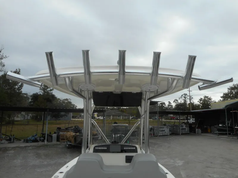 Slide: The Image of 2024 Avenger 24 Avenger boat with rod holders and T-top in a storage yard. - 7