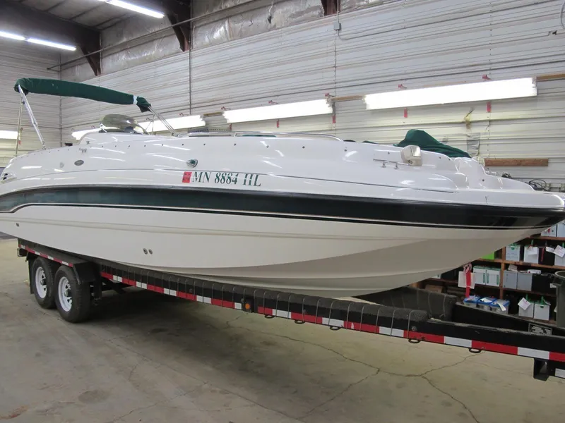 The Image of 1998 Chaparral 252 Sunesta boat on a trailer in a warehouse. - 1