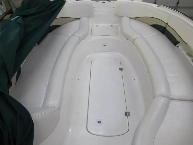 Slide: The Image of 1998 Chaparral 252 Sunesta boat interior with white seating and green cover. - 6
