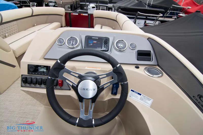 Slide: The Image of 2023 Crest Classic Platinum 240 SLC boat dashboard with steering wheel and control panel. - 28