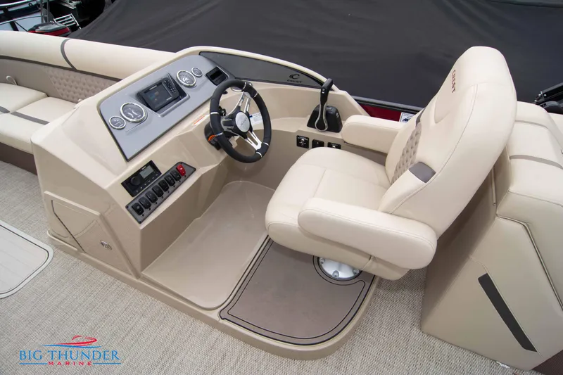 Slide: The Image of 2023 Crest Classic Platinum 240 SLC boat helm with beige captain's chair and control panel. - 34
