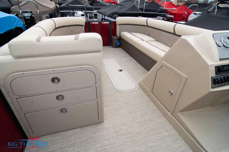 Slide: The Image of Interior of 2023 Crest Classic Platinum 240 SLC pontoon boat with beige seating and storage. - 36