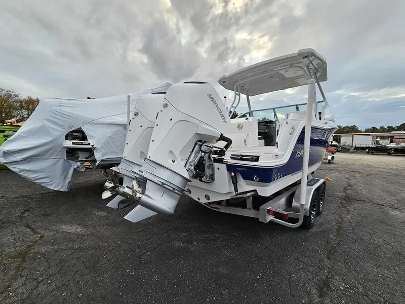Slide: The Image of 2024 Blackfin 252 DC boat with twin outboard engines on a trailer. - 2