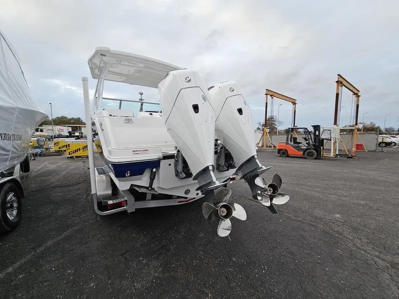 Slide: The Image of 2024 Blackfin 252 DC boat with dual outboard engines in a marina. - 3