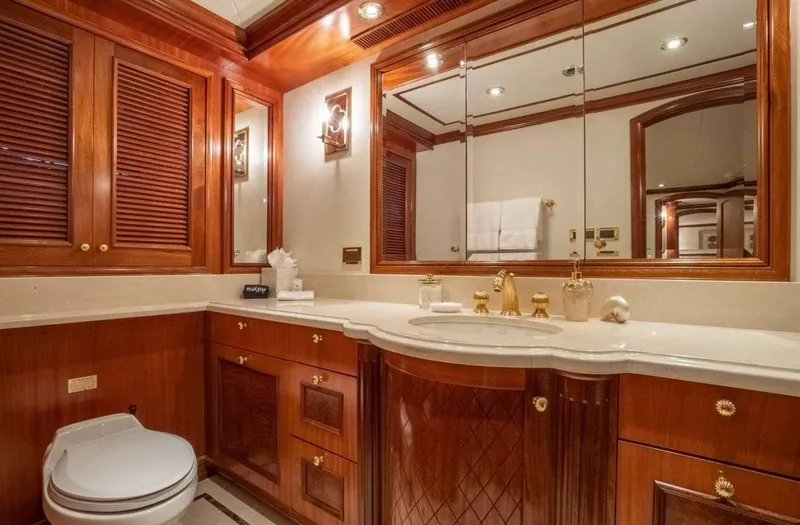 Slide: The Image of Luxurious yacht bathroom with wooden cabinetry, gold fixtures, and large mirror, Richmond Yachts 2004. - 31