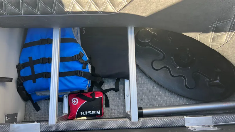 Slide: The Image of Storage compartment of 2020 Crest Classic Platinum 220 SLC with life jackets and first aid kit. - 17