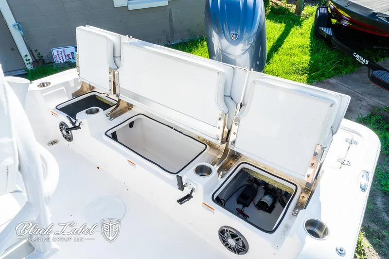 Slide: The Image of 2024 Sea Fox 231 Bay Fox Center Console with open storage compartments and engine view. - 23
