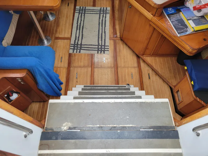 Slide: The Image of Interior of 1994 Jeanneau Sun Odyssey 51 yacht, featuring wooden flooring and cozy seating. - 20