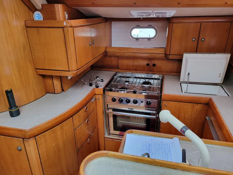 Slide: The Image of Interior of 1994 Jeanneau Sun Odyssey 51 yacht kitchen with wooden cabinetry and stove. - 21