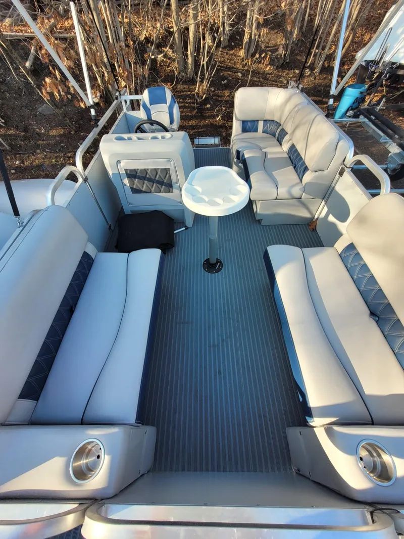 Slide: The Image of 2024 Pond-Tini Series 14 pontoon boat interior with spacious seating and table. - 3