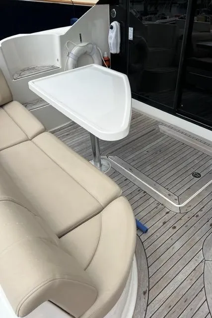 Slide: The Image of 2016 Sea Ray 510 Fly yacht interior with beige seating and white table. - 22