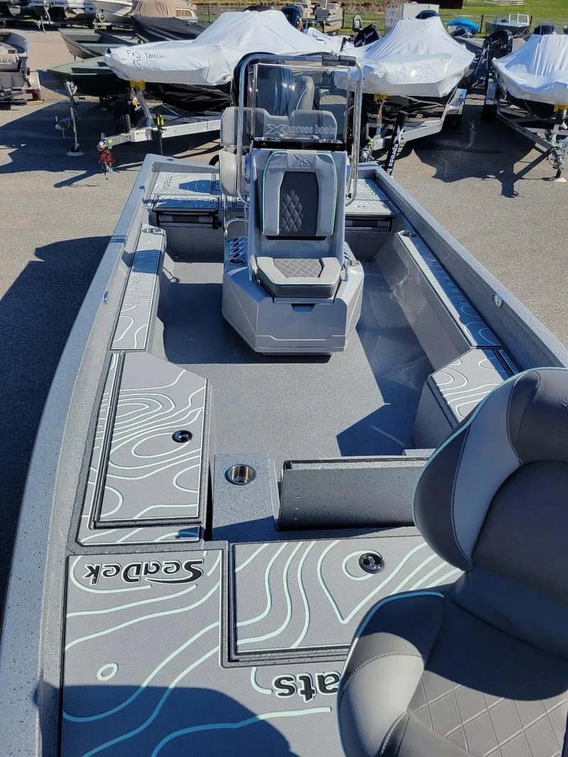 Slide: The Image of 2024 Xpress H24 Bay boat in stock, featuring Seadek flooring and modern seating. - 15