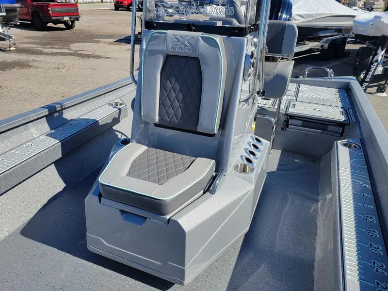 Slide: The Image of 2024 Xpress H24 Bay boat interior with cushioned seating and storage compartments. - 7
