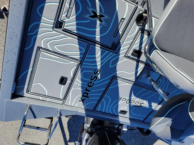 Slide: The Image of 2024 Xpress X23 Bay Lounge boat interior with stylish blue wave pattern flooring. - 12