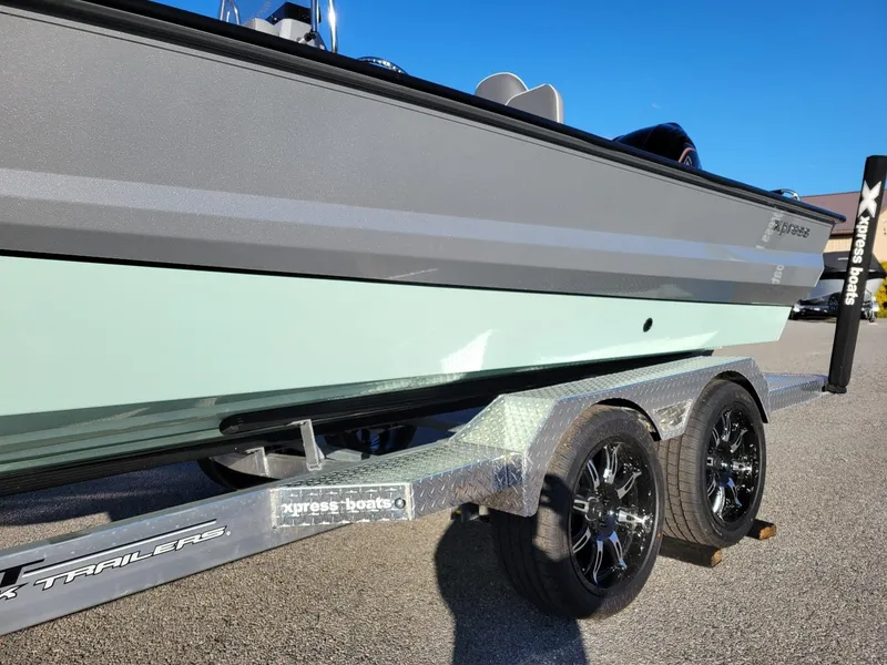 Slide: The Image of 2024 Xpress X23 Bay Lounge boat on trailer, side view, sunny day. - 14