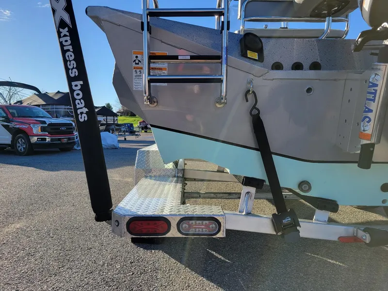 Slide: The Image of 2024 Xpress X23 Bay Lounge boat on trailer, showcasing rear ladder and branding. - 17