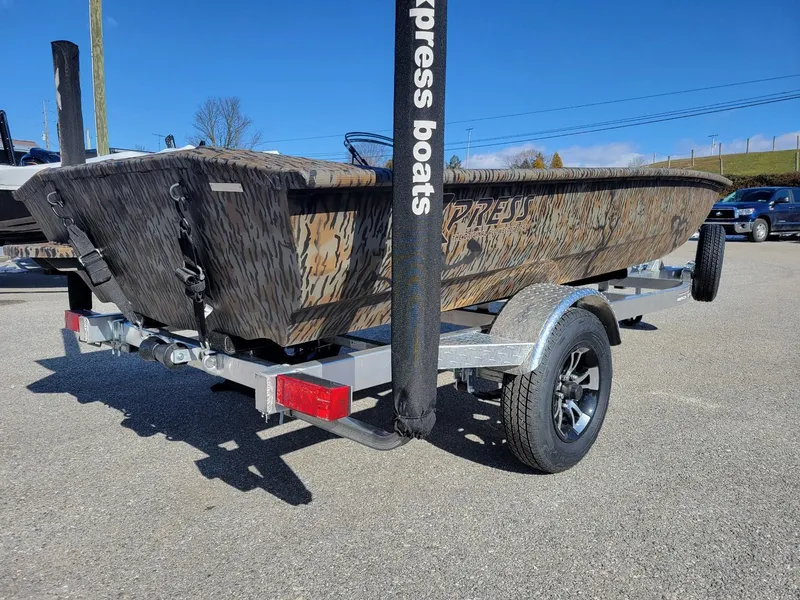 Slide: The Image of 2024 Xpress HD15DBX duck hunting boat on trailer, camo design, sunny day. - 3
