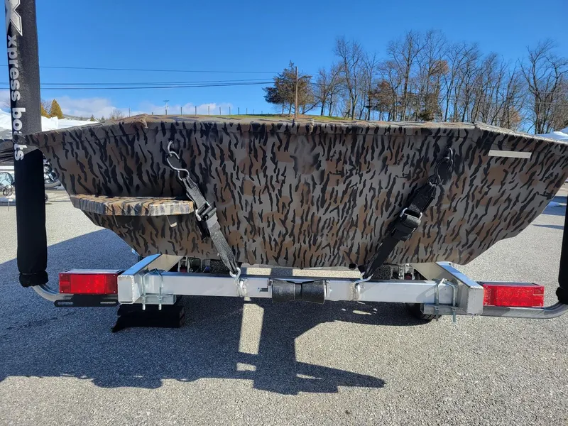 Slide: The Image of 2024 Xpress HD15DBX duck hunting boat with camouflage design on a trailer. - 4