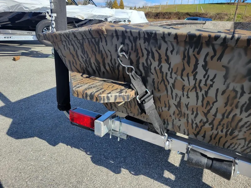 Slide: The Image of 2024 Xpress HD15DBX duck hunting boat with camouflage design on trailer. - 5