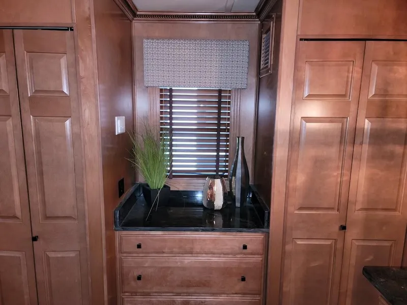 Slide: The Image of 2008 Sumerset Houseboat interior with wooden cabinets and decorative items. - 15