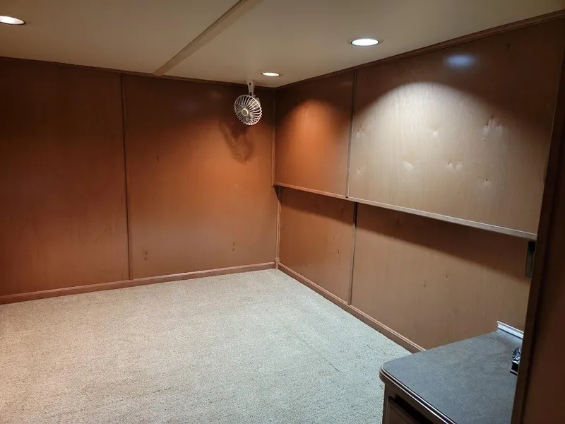 Slide: The Image of Interior of a 2008 Sumerset Houseboat with wooden walls and carpet flooring. - 23