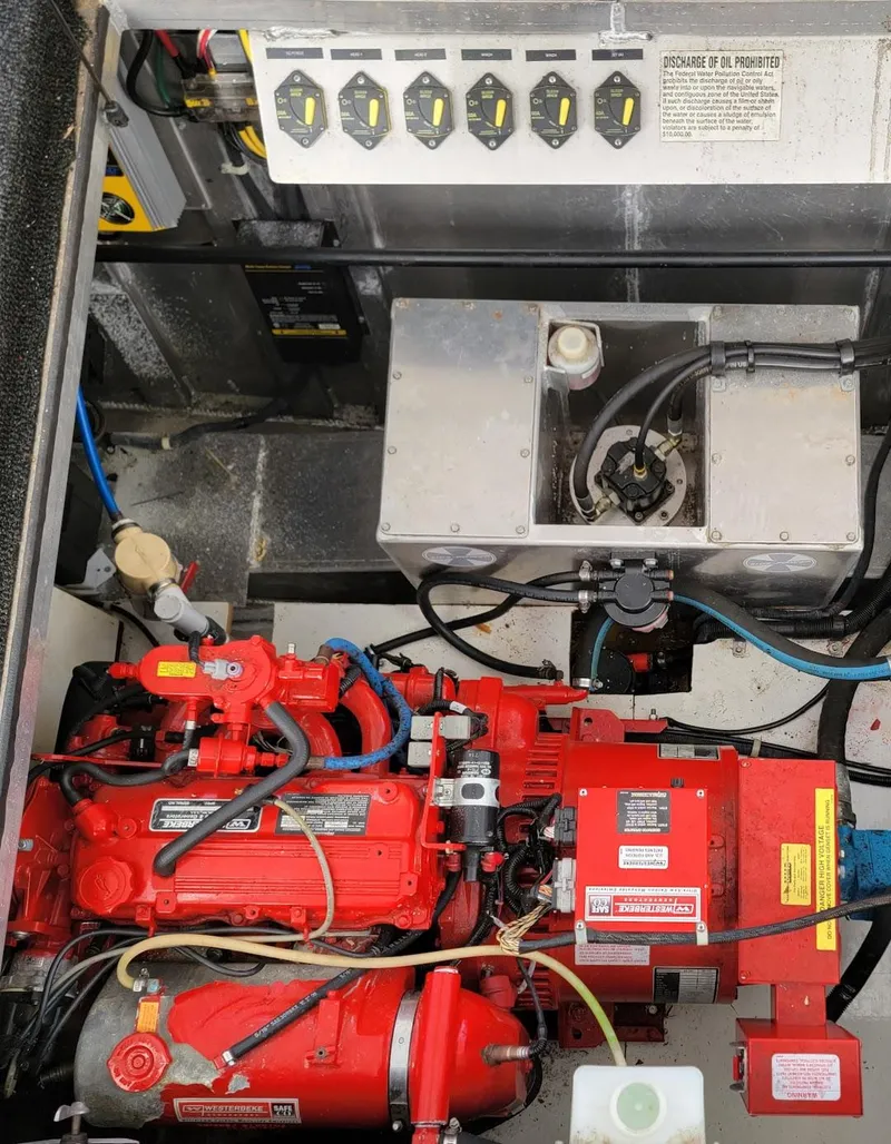 Slide: The Image of Engine compartment of a 2008 Sumerset Houseboat with red machinery and control panel. - 33