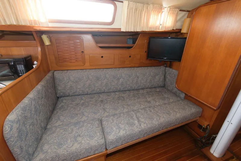 Slide: The Image of 1984 Sabre 38 MK I sailboat interior with cushioned seating and wooden cabinetry. - 8