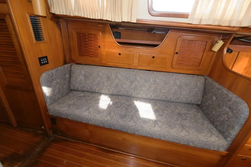 Slide: The Image of 1984 Sabre 38 MK I sailboat interior with cushioned seating and wooden cabinetry. - 9