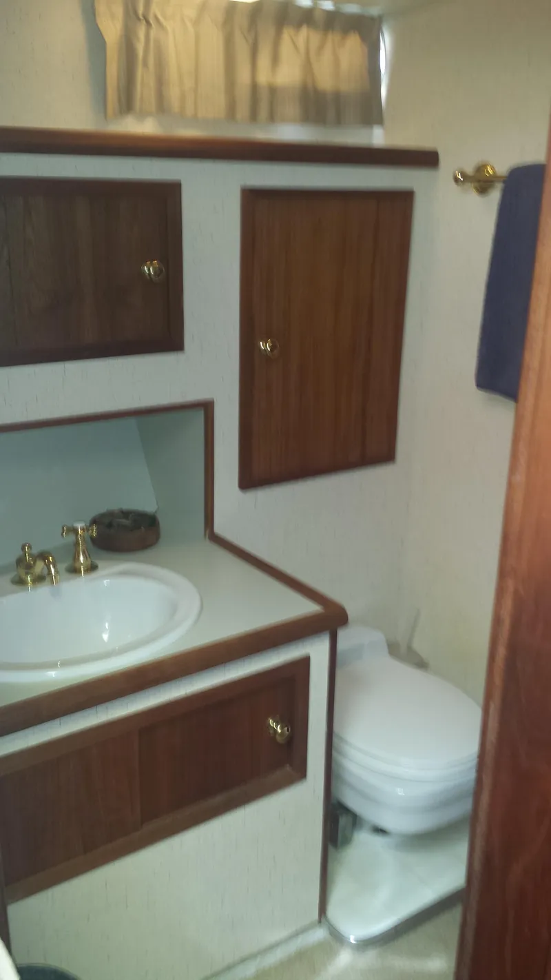 Slide: The Image of 1975 Uniflite Aft Cabin interior with bathroom and wooden cabinets. - 25