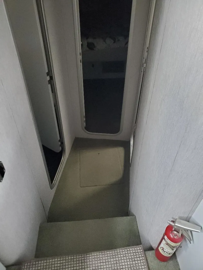 Slide: The Image of Interior view of 1990 Mainship Mediterranean yacht with stairs and fire extinguisher. - 17