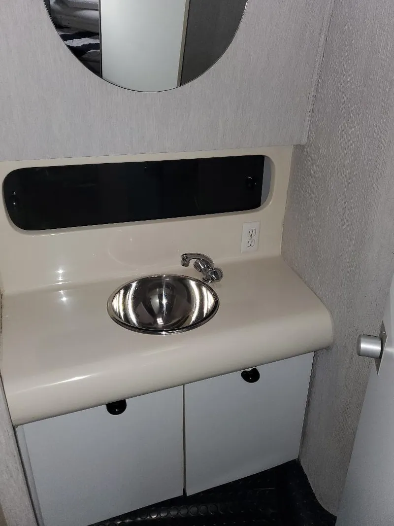 Slide: The Image of 1990 Mainship Mediteranian bathroom sink with mirror and storage cabinets. - 18