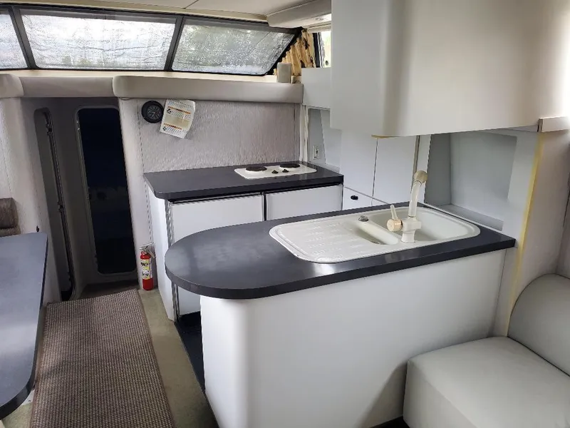 Slide: The Image of 1990 Mainship Mediterranean yacht interior with modern kitchen, featuring sink and stove. - 5