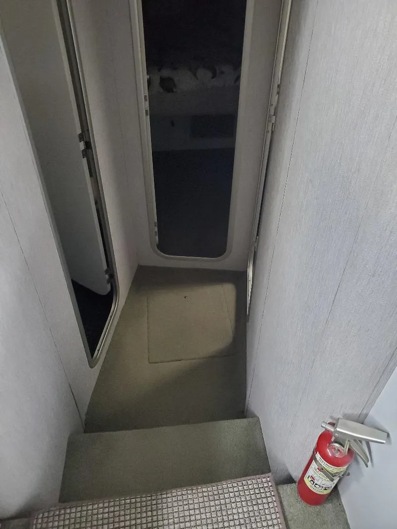 Slide: The Image of 1990 Mainship Mediteranian interior hallway with stairs and fire extinguisher. - 13