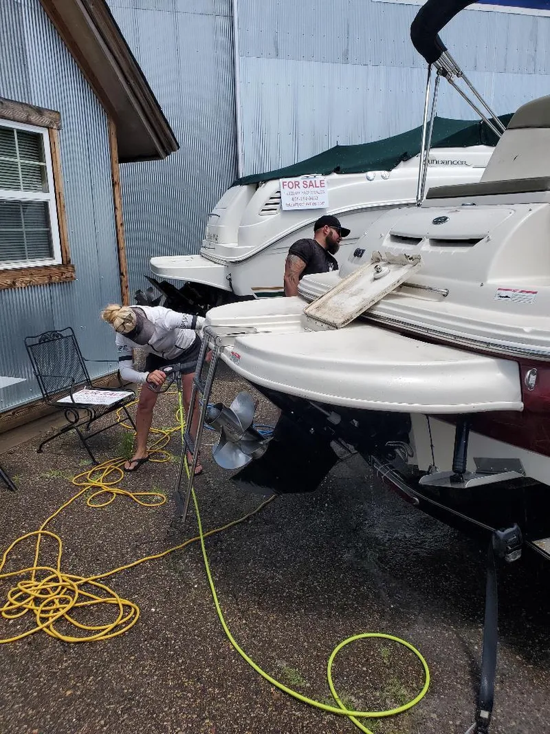 Slide: The Image of Two people cleaning a 1990 Mainship Mediterranean boat, with a "For Sale" sign visible. - 21
