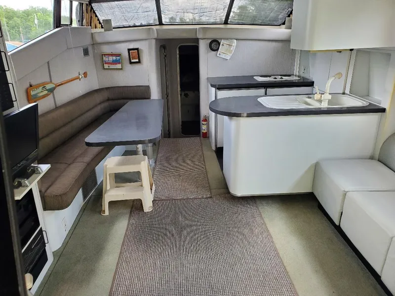 Slide: The Image of 1990 Mainship Mediterranean yacht interior with seating, table, and kitchenette. - 3